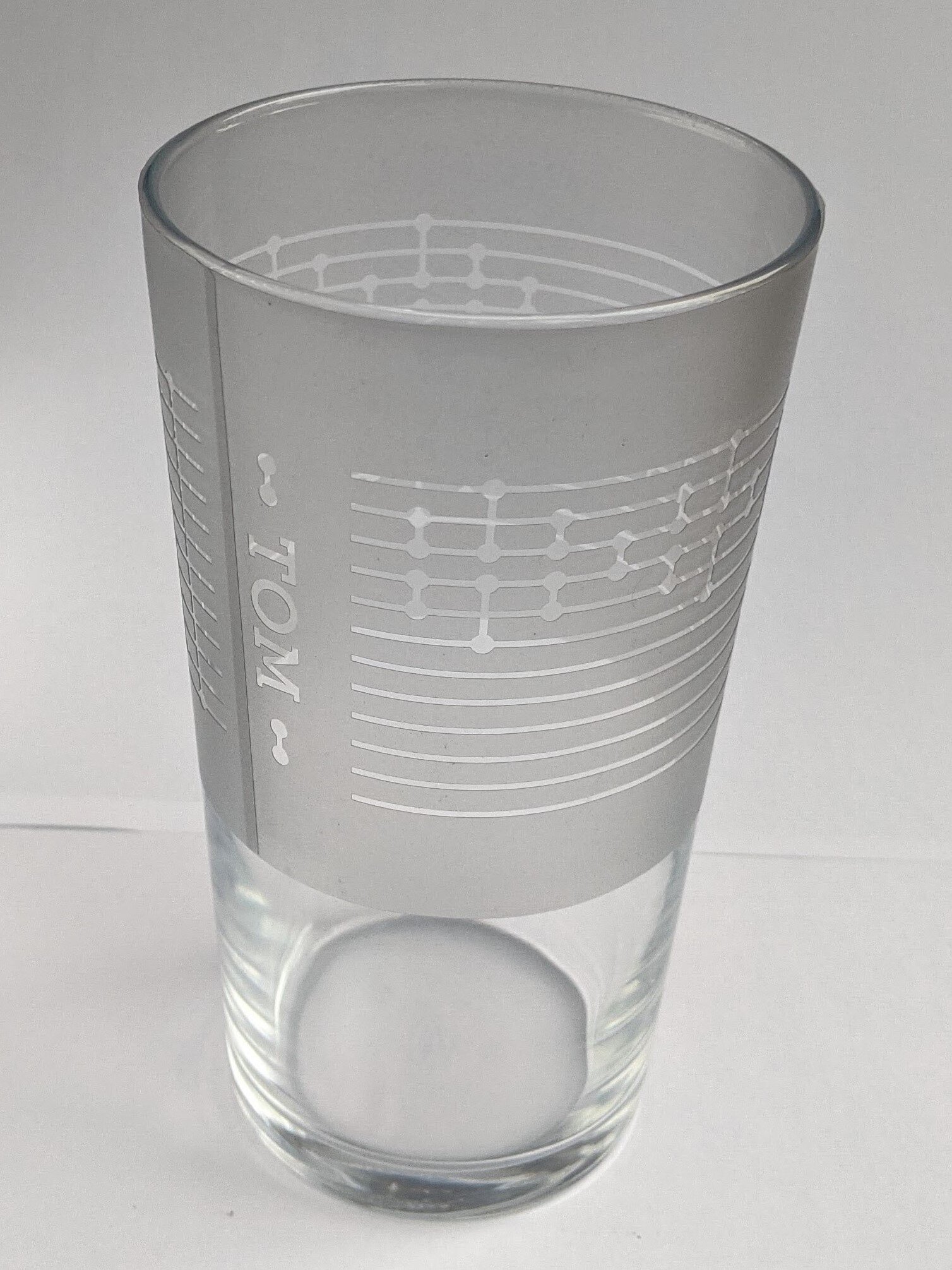 A pint glass with the stencil wrapped round.